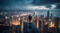 A man stands on a skyscraper and looks out over an evening Hong Kong city. Royalty Free Stock Photo