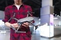 Man stands in a technology store and holds a quadcopter in his hand. Buying a quadcopter in the electronics store