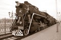 A man stands on a vintage train. The man shows forward on an old steam locomotive. Retro Union head car of the train. ÃËlack-white Royalty Free Stock Photo