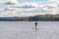 Man standup paddle boarding. Image of young man SUP surfing on the lake