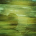 A man staring at his smartphone. Reflection in the moving train.