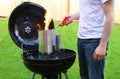 Man starting BBQ coal chimney fire with lighter
