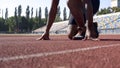 Man in starting position on track, professional runner training at stadium