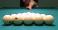 A man starts a game of billiards by breaking the balls with an accurate cue hit. The man takes aim and hits the pool cue Royalty Free Stock Photo