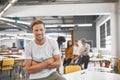 Man, startup and modern office in portrait, arms crossed or smile with excited face for career. Young businessman