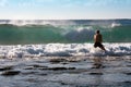 Man stay in the rock beach and look on big waves. Sunny day.