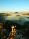 Man stay on the rocky peak and within daybreak watch over the misty and foggy morning valley. Beautiful autumn morning. Royalty Free Stock Photo