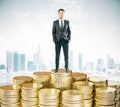 Man stays on piles of coins concept at city background Royalty Free Stock Photo