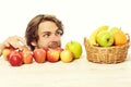 Man stealing apple from wooden table near fruit basket Royalty Free Stock Photo