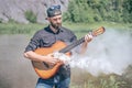 Man with a steaming acoustic guitar