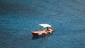 Man steering a boat in perfectly blue ocean water in the Mediterranean Royalty Free Stock Photo