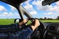 Man steers auto. Driving car on nature. Green field countryside landscape along the road Royalty Free Stock Photo