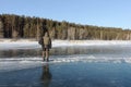 Man stepping over a crack on thin ice of a frozen river Royalty Free Stock Photo