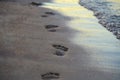 Man steps on the sand on the sea beach in the evening.