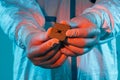 A man in sterile form holds a microprocessor, close-up. Microchip production technology, modern production, special microcircuit.