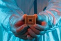 A man in sterile form holds a microprocessor, close-up. Microchip production technology, modern production, special microcircuit.