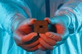 A man in sterile form holds a microprocessor, close-up. Microchip production technology, modern production, special microcircuit.