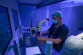 Man in sterile uniform conducting researches under microscope Royalty Free Stock Photo