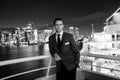 Man steward on ship board at night in miami, usa. Macho in suit jacket on city skyline. Water transport, transportation Royalty Free Stock Photo