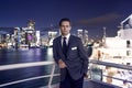 Man steward on ship board at night in miami, usa. Macho in suit jacket on city skyline. Water transport, transportation Royalty Free Stock Photo