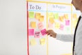 Man with sticker near scrum task board in office Royalty Free Stock Photo