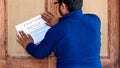 Man sticking eviction notice on the door of the tenant