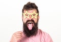 Man with stickout tongue, closed eyes and beard wearing paper star shaped glasses, fun concept. Hipster with crazy look