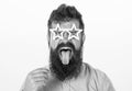 Man with stickout tongue, closed eyes and beard wearing paper star shaped glasses, fun concept. Hipster with crazy look Royalty Free Stock Photo