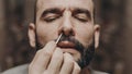 man sticks nasal swab in nose of covid antigen test