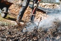 man stirs the dry plant remains in a bonfire Royalty Free Stock Photo