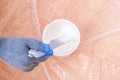 A man stirs white acrylic paint with special plastic stirrer. Painting the door.