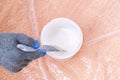 A man stirs white acrylic paint with special plastic stirrer. Painting the door. Royalty Free Stock Photo