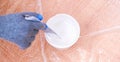 A man stirs white acrylic paint with special plastic stirrer. Painting the door.