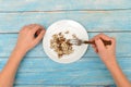Man stirs wooden letters with a fork on a plate, choosing between food and knowledge. Carnal joys or spiritual truths Royalty Free Stock Photo