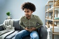 Man With Stomach Ache Sitting On Couch At Home Royalty Free Stock Photo