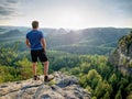 Man on a stone observing the landscape. Young sportsman