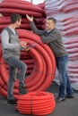 Man stood by industrial sized reels red conduit Royalty Free Stock Photo