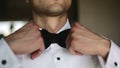The man straightens his tie. Close up