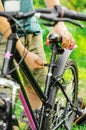 A man straightens, repairs the seat of a mountain bike on a forest road. Bicycle breakdown, vehicle repair. Royalty Free Stock Photo