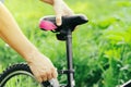 A man straightens, repairs the seat of a mountain bike on a forest road. Bicycle breakdown, vehicle repair. Royalty Free Stock Photo