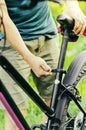 A man straightens, repairs the seat of a mountain bike on a forest road. Bicycle breakdown, vehicle repair. Royalty Free Stock Photo