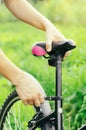A man straightens, repairs the seat of a mountain bike on a forest road. Bicycle breakdown, vehicle repair. Royalty Free Stock Photo