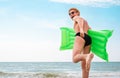 Man in straw hat runs with air swimimg mattress in the sea