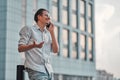 Man on the street. Happy young businessman talking on cell phone near business center Royalty Free Stock Photo
