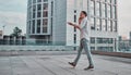 Man on the street. Happy young businessman talking on cell phone near business center and walking Royalty Free Stock Photo