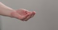 Man stretches empty cupped hand on neutral background Royalty Free Stock Photo