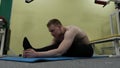 Man stretching arm before gym workout. Fitness strong male athlete standing indoor warming up.