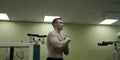 Man stretching arm before gym workout. Fitness strong male athlete standing indoor warming up.