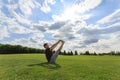 Man stretching hands and legs on green grass in park. Yoga and healthy lifestyle concept Royalty Free Stock Photo