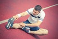 Man stretching leg on the running track Royalty Free Stock Photo